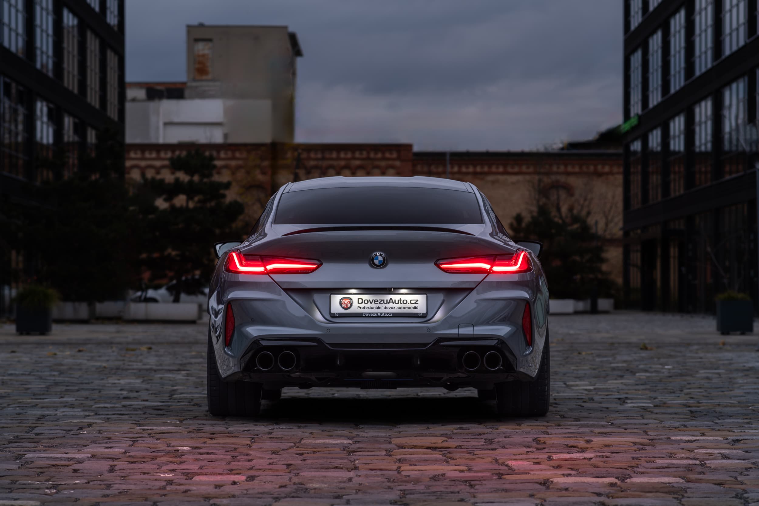 BMW M8 Competition Gran Coupé vyfocené zezadu s rozsvícenými zadními světly