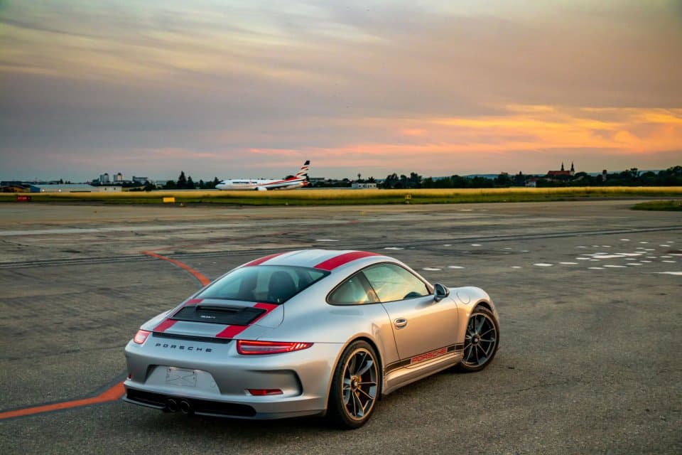 Porsche 911R vyfocené zezadu na letištní dráze v pozadí s letadlem