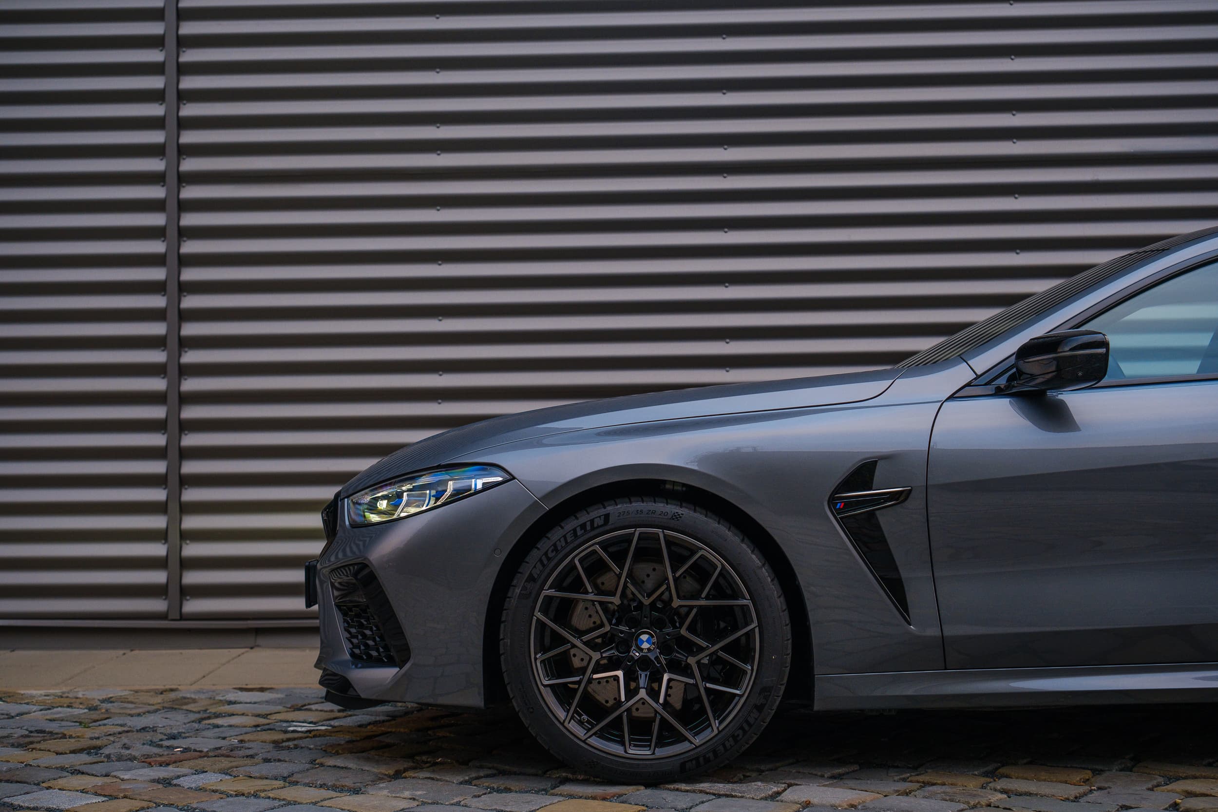 Detailní záběr na přední část BMW M8 Competition Gran Coupé zboku