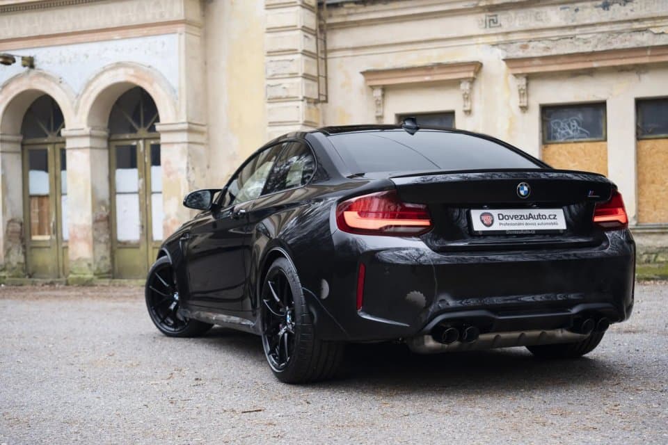 BMW M2 vyfocené zezadu v pozadí se starou budovou